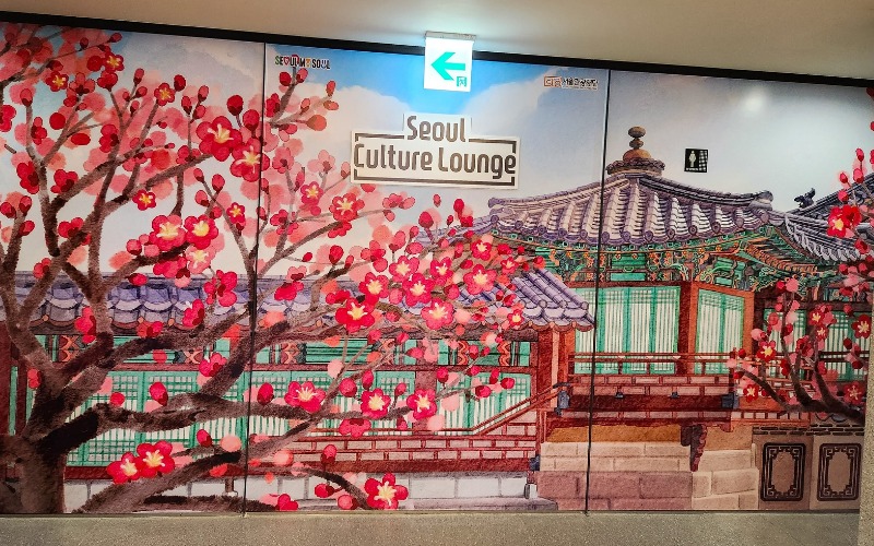 Une fresque d’une architecture traditionnelle coréenne entourée de cerisiers à l'entrée du Seoul Culture Lounge. © Imane Bouhnika