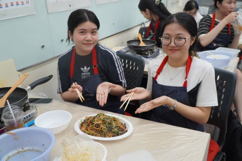 Hai bạn học viên háo hức trưng bày thành phẩm món Japchae trong buổi học “K-Food - Món ăn cung đình mà vua Gwanghaegun yêu thích [Japchae]” của Học viện King Sejong Hồ Chí Minh 2. (Ảnh: Học viện King Sejong Hồ Chí Minh 2)