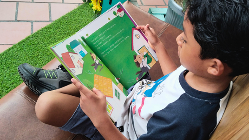 Mi hijo disfrutando las ilustraciones de los libros coreanos, ahora sueña con viajar a Corea y aprender su idioma.