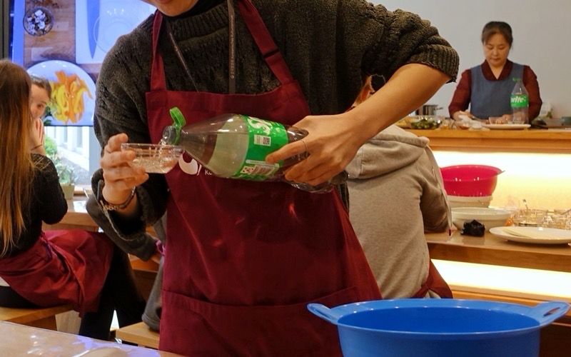 Sprite für die Sauce wird von einer Mitarbeiterin des Koreanischen Kulturzentrums verteilt