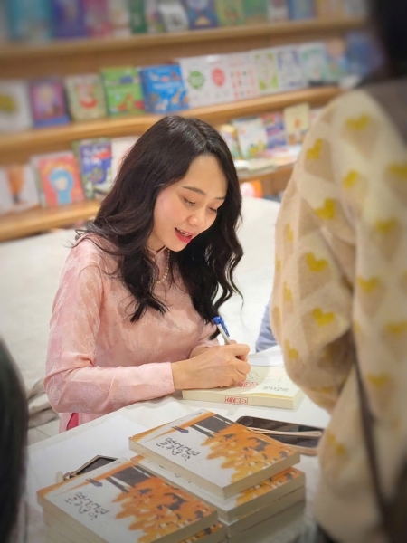 Dịch giả Nguyễn Thị Thu Vân ký tặng sách  “Bố con cá gai” trong sự kiện giao lưu với độc giả được tổ chức tại Lotte Westlake ngày 9/3/2025. (Ảnh: Nguyễn Thị Thu Vân)