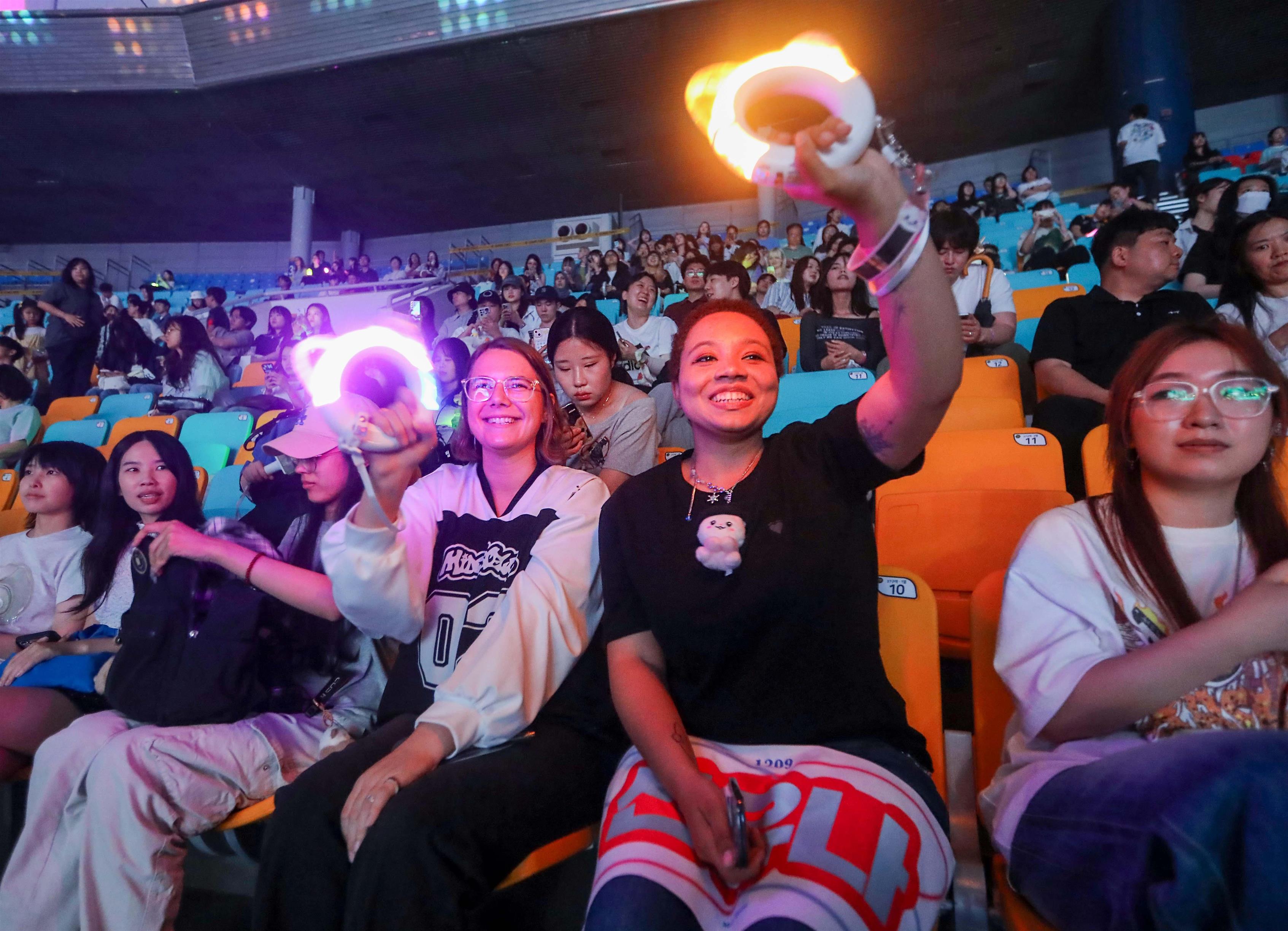 Asistentes internacionales disfrutan del concierto con lightsticks en mano durante el MyK LIVE STAGE. | Ministerio de Cultura, Deportes y Turismo
