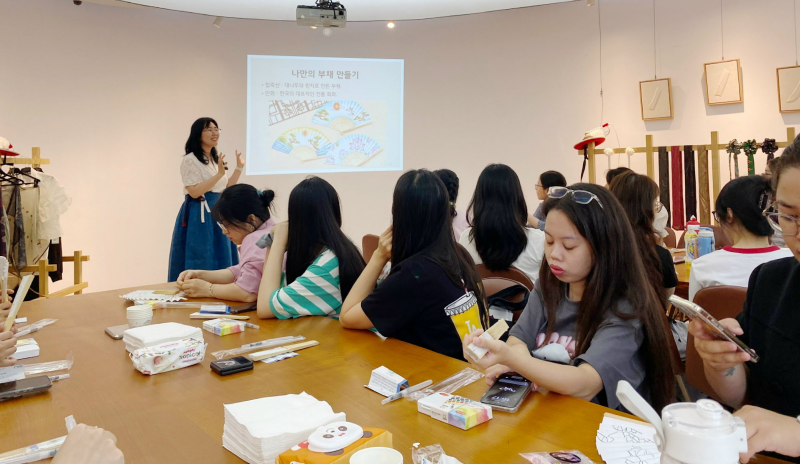 Các bạn học viên chăm chú lắng nghe cô giáo hướng dẫn cách sử dụng bộ dụng cụ trải nghiệm. (Ảnh: Tô Trà My)