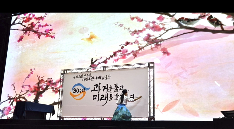 Với thời lượng biểu diễn nhất định, nghệ sĩ Kim Hye-jin trong trang phục Hanbok sẽ thực hiện tác phẩm thư pháp trực tiếp ngay trên sân khấu với khổ vải và cọ có kích thước lớn. (Ảnh: Kim Hye-jin)