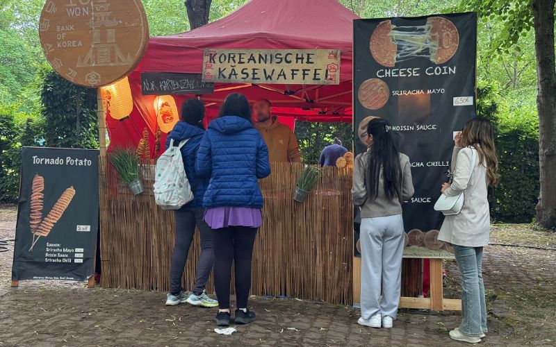 Besucherinnen des Street-Food-Festivals warten vor einem Verkaufsstand auf ihren 10-Won-Pfannkuchen (십원빵).