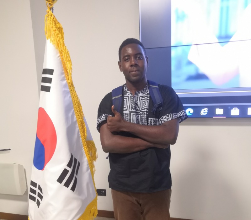 Yann, l'un des finalistes, pose fièrement aux cotes du drapeau coréen. © Isaac Ngoufan