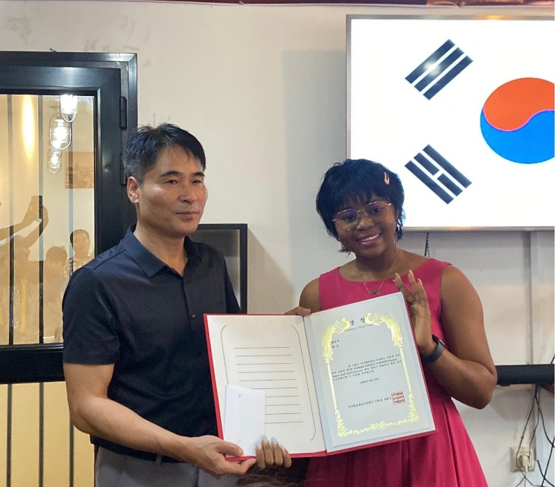 Laeticia recevant son certificat d'honneur après sa prestation lors du concours de discours. © Isaac Ngoufan